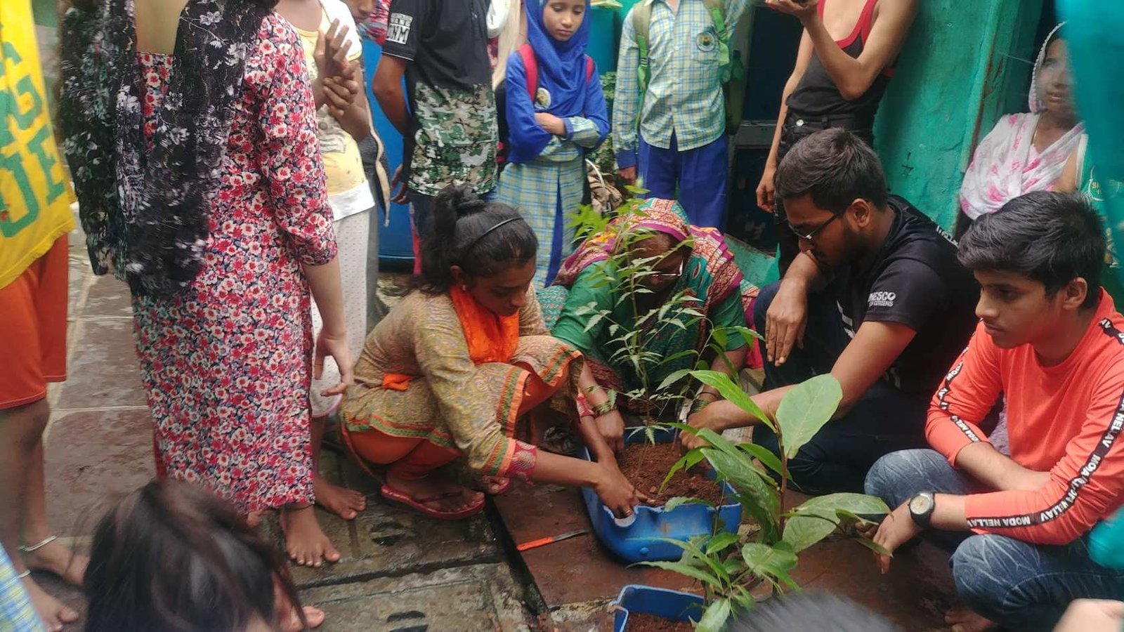 Earth5R community women receiving payment for saplings grown on slum rooftops — horticulture livelihood programme income generation