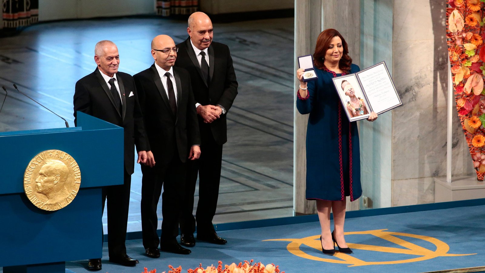 Ouided Bouchamaoui holding the Nobel Peace Prize diploma with fellow representatives of the Tunisian National Dialogue Quartet in Oslo