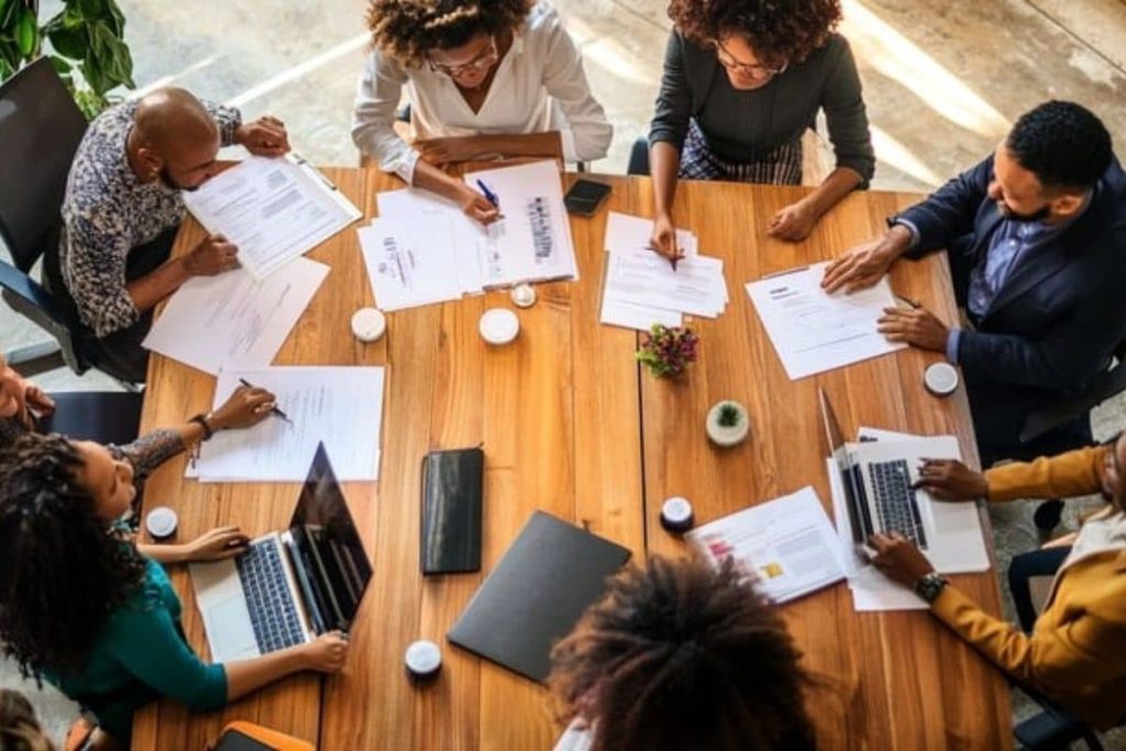 A corporate team at a wooden table develops an ESG sustainability roadmap with guidance from Earth5R.