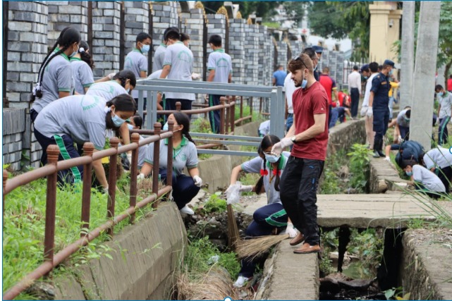 Young volunteers and students participating in a community environmental cleanup event, demonstrating the social and environmental aspects of ESG