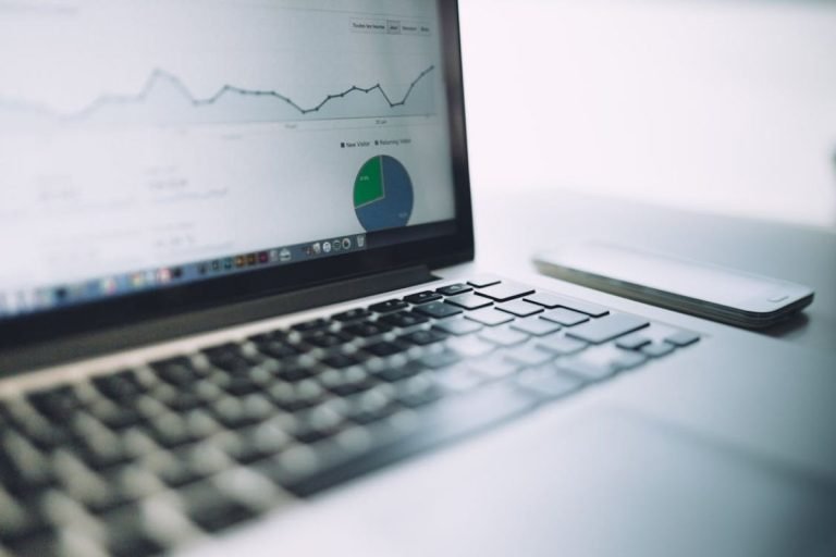 A laptop displays a carbon accounting SaaS dashboard, showing emissions data and sustainability performance metrics for an ESG report.