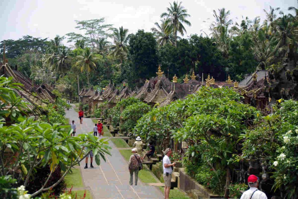 Tourists exploring a traditional eco-village surrounded by lush greenery, representing Earth5R’s community-led sustainable tourism initiatives that promote Waste Management, Sustainability, ESG, and CSR practices in Mumbai.