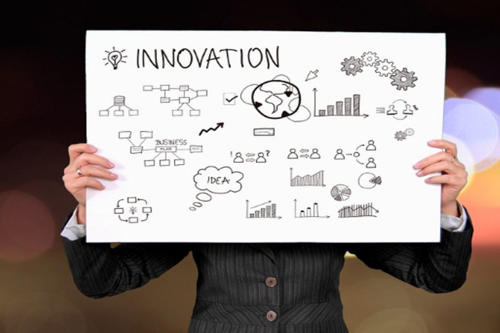 A professional holding a whiteboard with innovation and sustainability sketches, including charts, gears, and a globe, symbolizing creative ESG and CSR strategies promoting sustainable development and circular economy initiatives like Earth5R NGO in Mumbai.