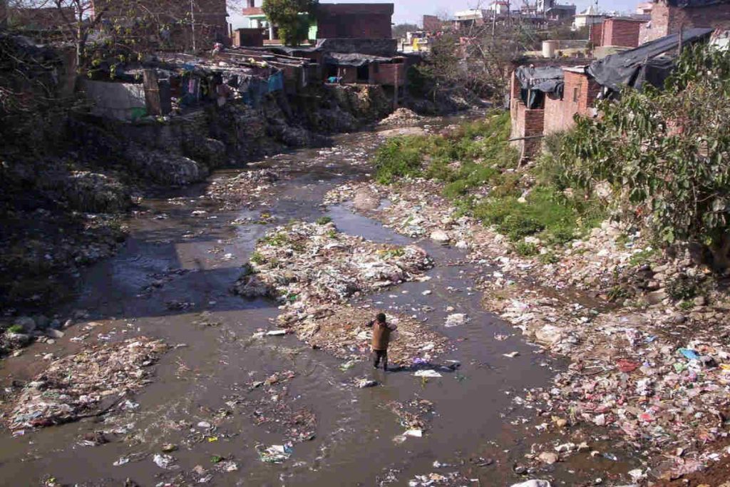 Polluted river in an urban area filled with plastic waste, highlighting India’s water pollution crisis and the urgent need for sustainable waste management and ESG-led clean river initiatives.