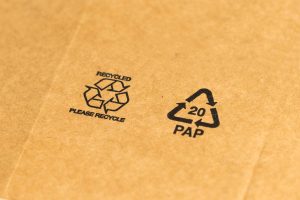 Recycled cardboard packaging showing sustainability symbols including the recycled and PAP 20 paper recycling codes, representing eco-friendly waste management practices by Earth5R NGO in Mumbai promoting ESG and CSR initiatives.