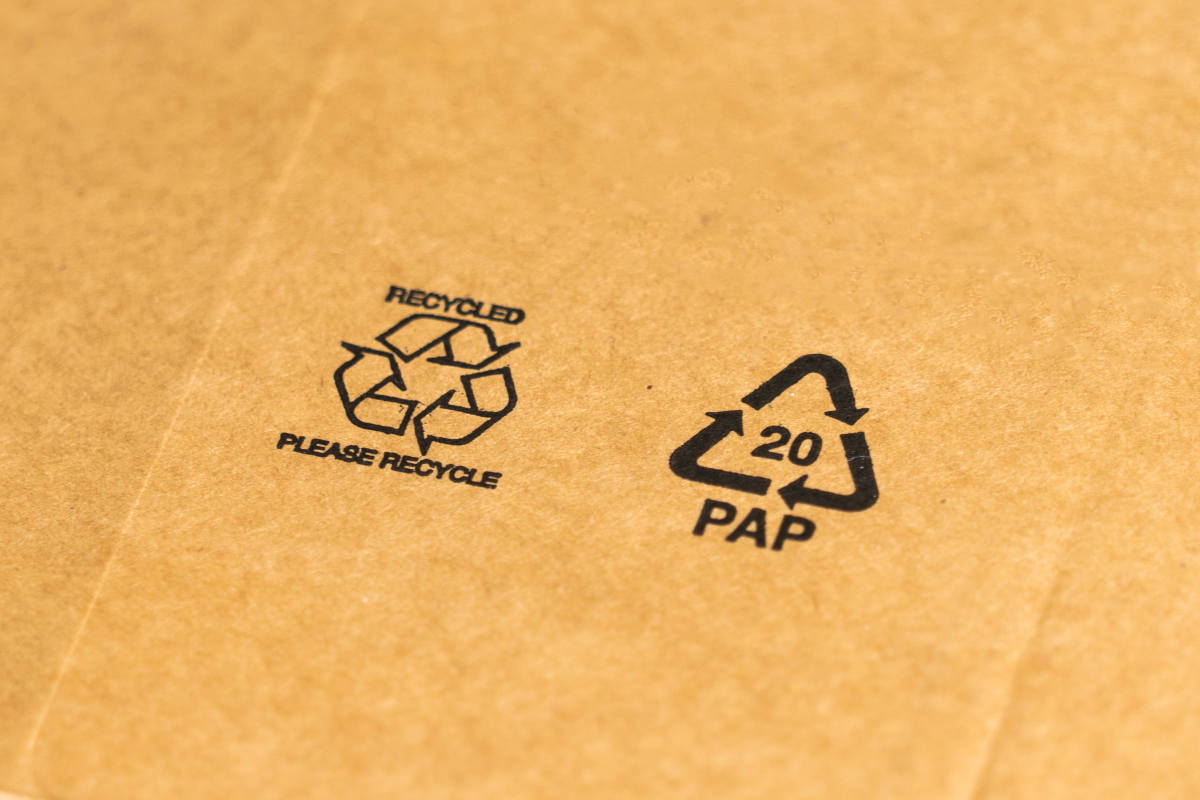 Recycled cardboard packaging showing sustainability symbols including the recycled and PAP 20 paper recycling codes, representing eco-friendly waste management practices by Earth5R NGO in Mumbai promoting ESG and CSR initiatives.