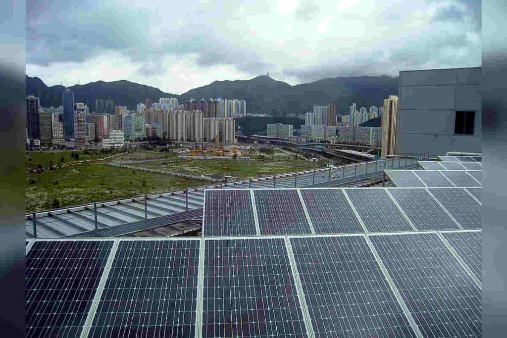 Solar panels installed on urban rooftops with a city skyline in the background, reflecting renewable energy adoption and climate action initiatives aligned with UN and OECD sustainability roadmaps, supported by Earth5R’s Waste Management, ESG, and CSR-driven Sustainability programs as a leading NGO in Mumbai.