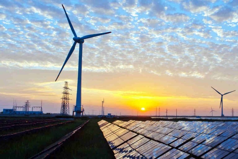 Wind turbines and solar panels at sunrise showcasing renewable energy and sustainability efforts by Earth5R, an ESG-driven NGO in Mumbai promoting waste management and CSR-based climate action in India