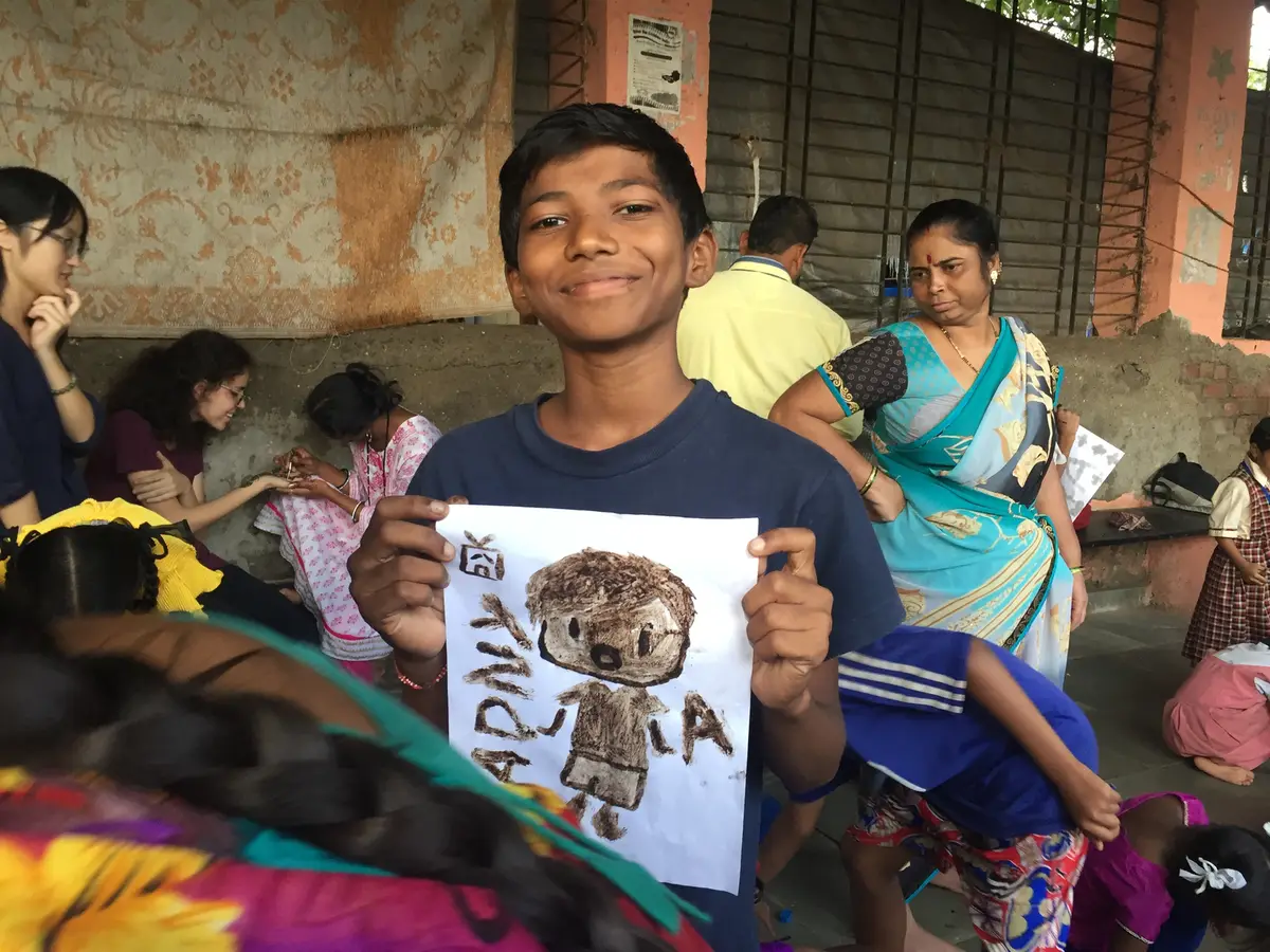 Smiling boy holding up his drawing at a community workshop, Earth5R CSR programme in Mumbai