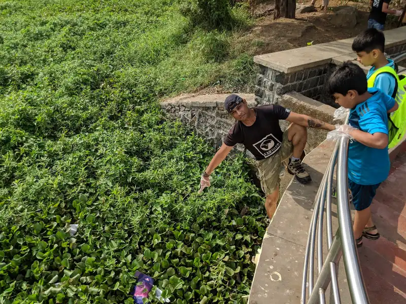 Local child helping an Earth5R volunteer on a weekend cleanup at Powai Lake, Mumbai