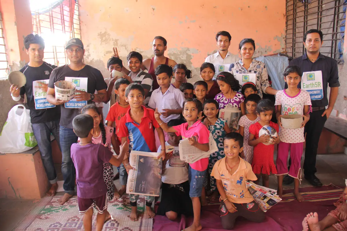 Children and Earth5R volunteers holding up upcycled paper bowls in a group photo, Earth5R CSR programme