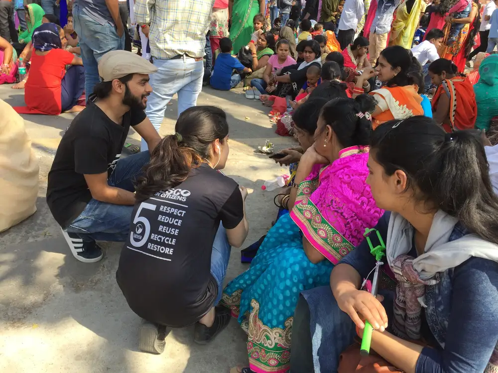 Earth5R volunteers sitting with families to train them on circular economy in a Delhi public space