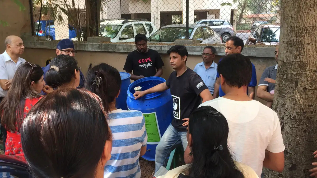 Residents gathered for Earth5R composting training around a drum composter in Mumbai