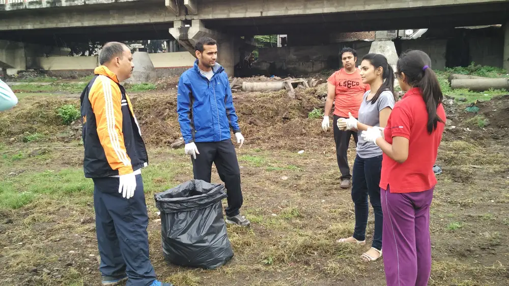 Hexaware employees collecting waste on the Mula Mutha riverbank in Pune with Earth5R volunteer team leader Sonam Sengar
