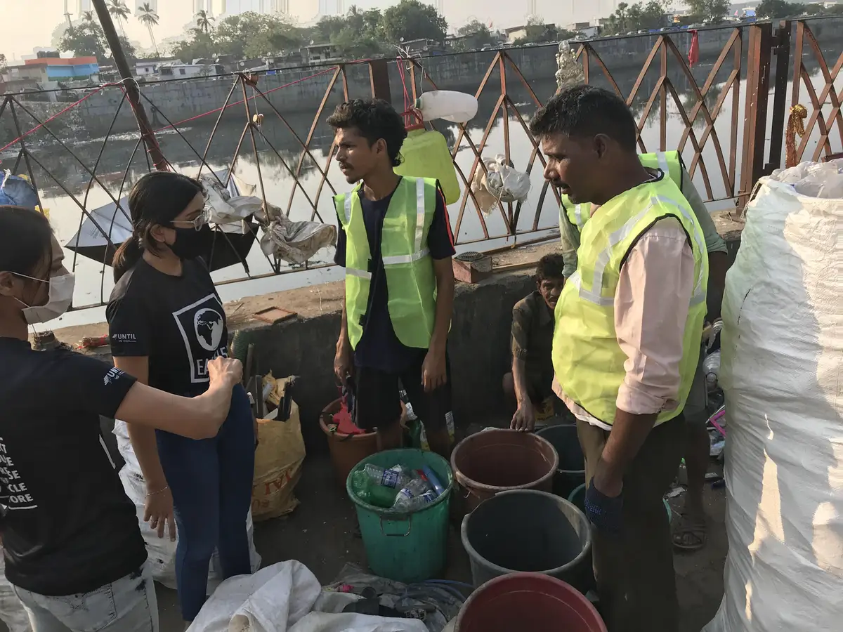 Earth5R team discussing plastic recovery targets with local collectors at the Mithi River in Mumbai