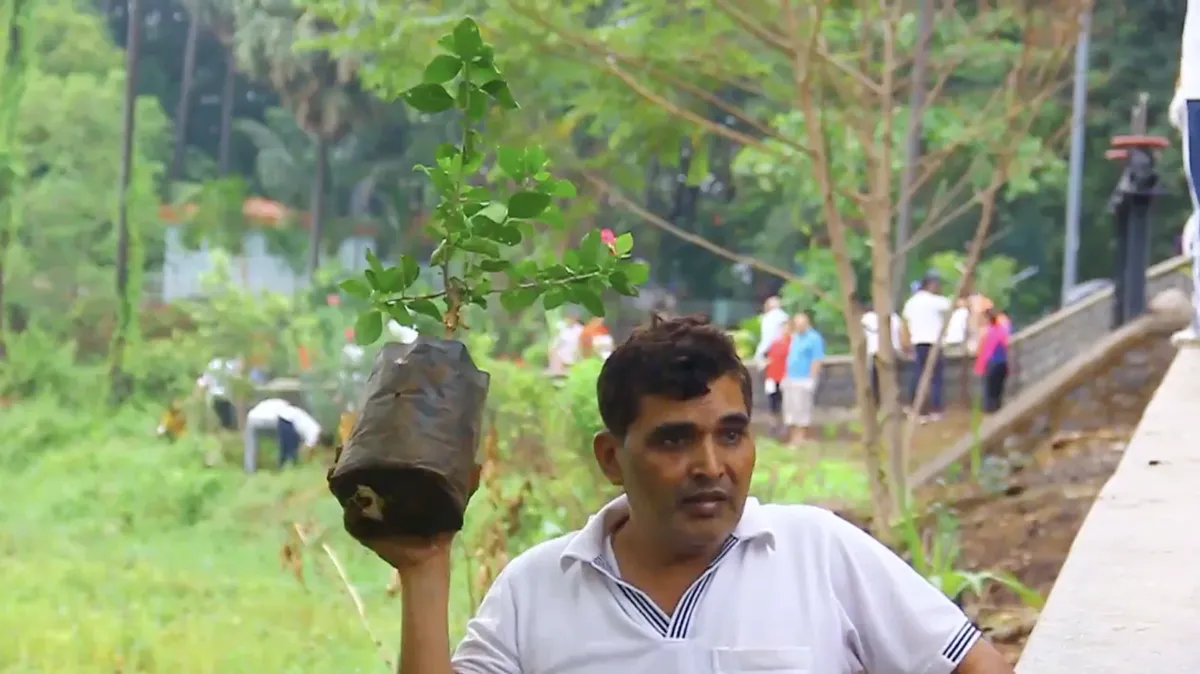 Volunteer holding a sapling at an Earth5R CSR plantation drive