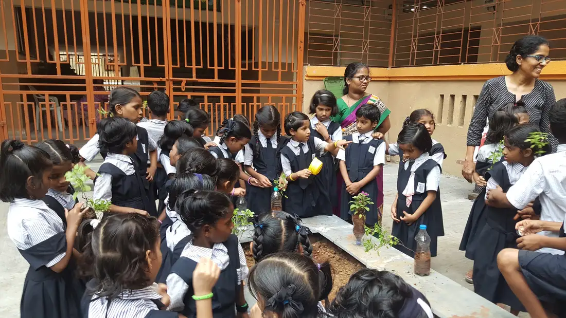 School children holding saplings during an Earth5R plantation and sapling care session