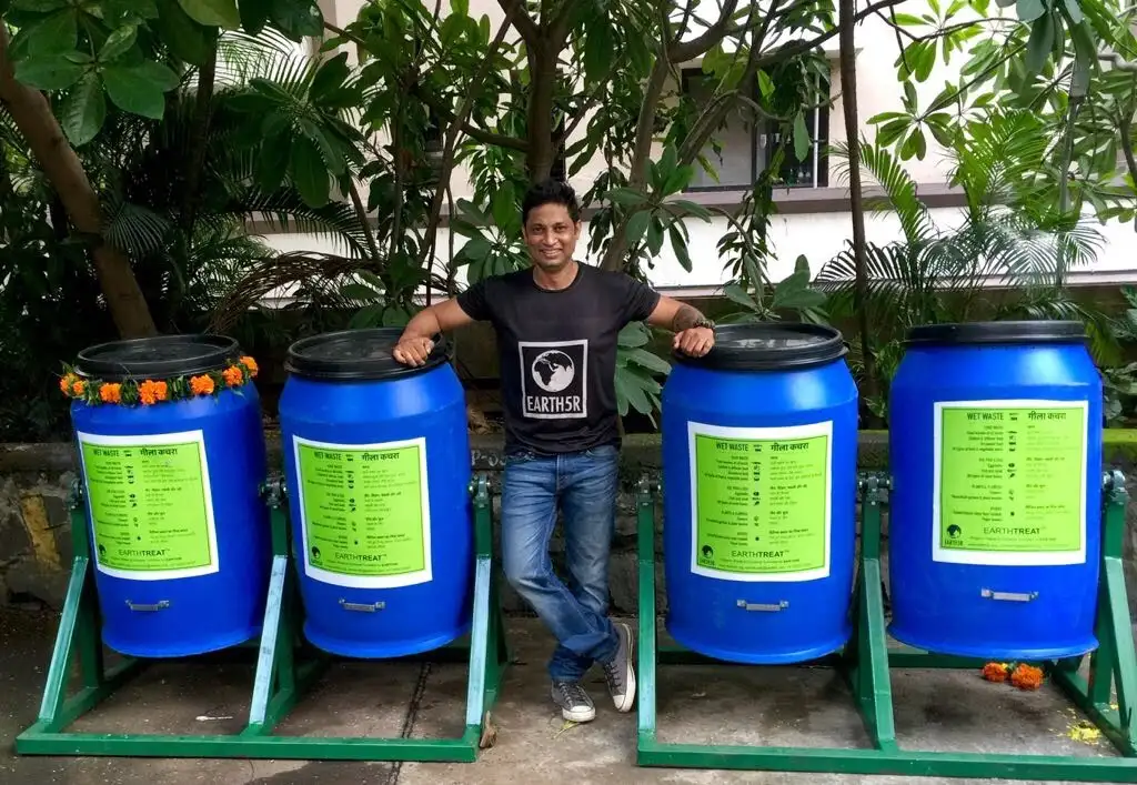 Saurabh Gupta standing between four Earth5R composting drums made from upcycled industrial containers, ready for a housing society