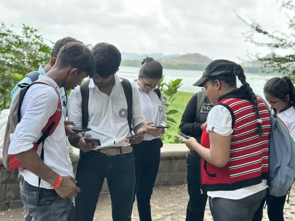 Student volunteers downloading the Earth5R app to log data at a lake cleanup in Mumbai