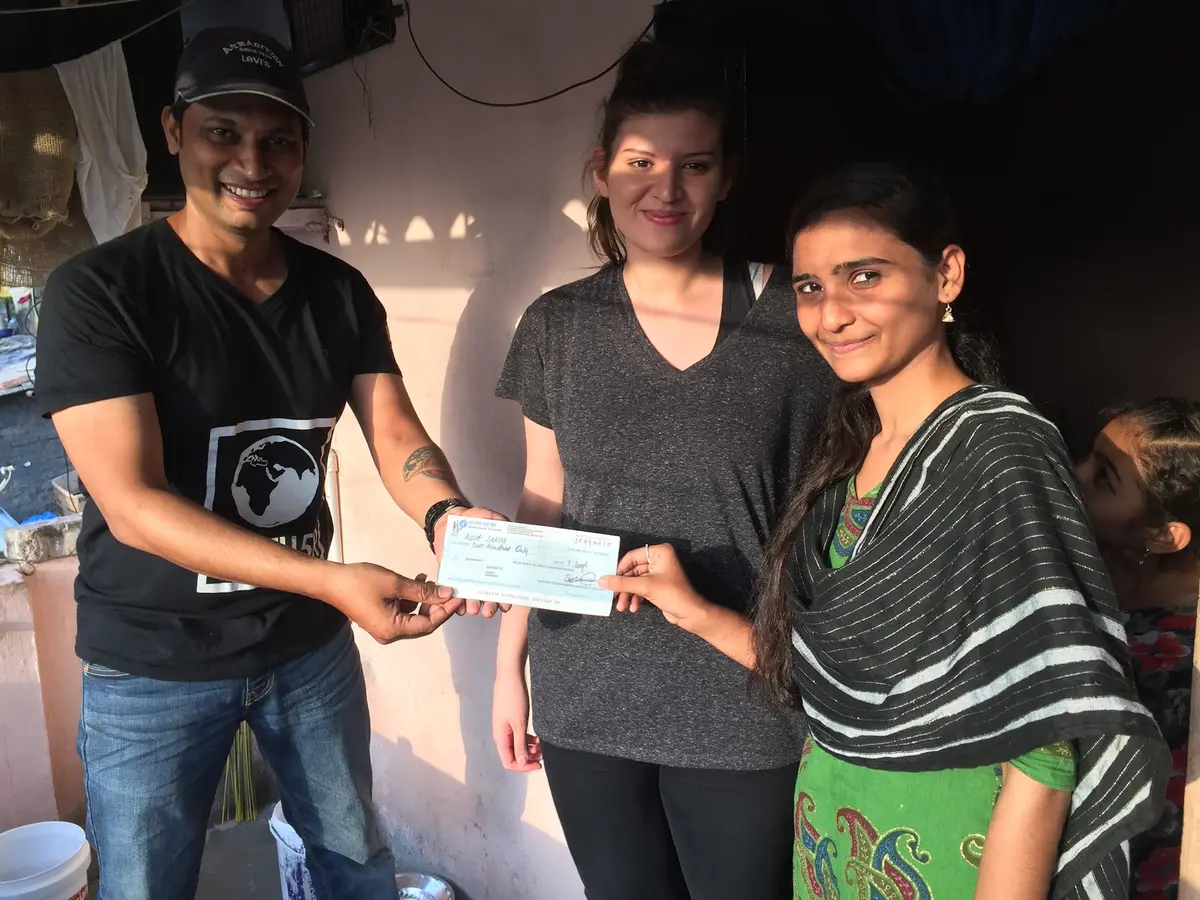 High school economics internship field work. Earth5R paying a woman by cheque for her paper bags, part of its financial inclusion programme