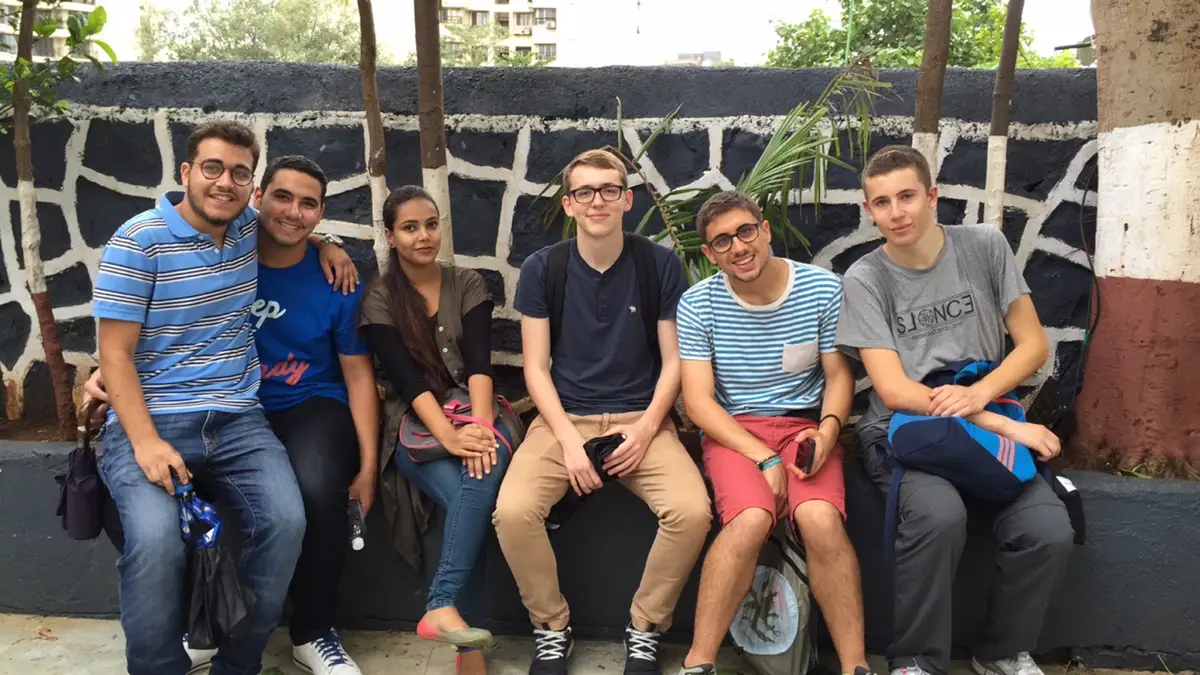 High school international relations internship field work. Group of international student volunteers seated outdoors, Earth5R CSR programme