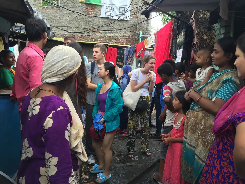 International student volunteers meeting residents in a settlement lane, Earth5R CSR programme in Mumbai