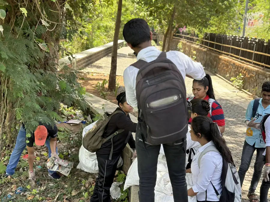 High school environmental science internship field work. Student volunteers collecting waste in the lake area during an Earth5R cleanup in Mumbai