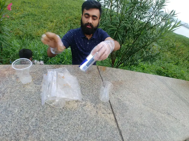 Earth5R volunteer sorting plastic cups and cans recovered at a lake cleanup