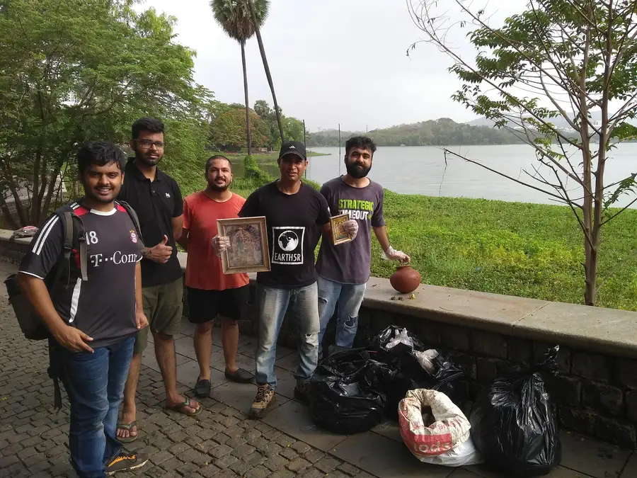 Earth5R volunteers with the waste and religious items they recovered from Powai Lake, Mumbai