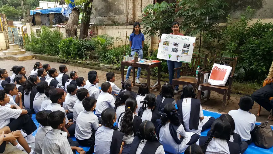 Earth5R volunteers running an outdoor environmental workshop for school children with charts