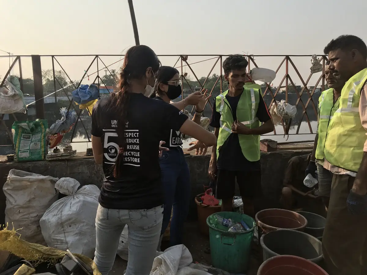 Earth5R trainers working with waste collectors at a plastic sorting point on the Mithi riverbank in Mumbai