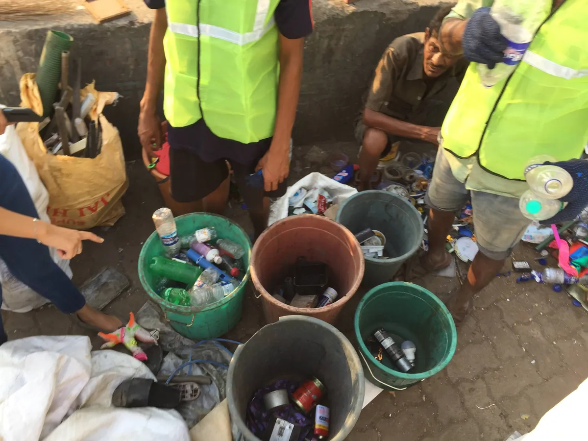 Waste collectors sorting plastic bottles and containers into buckets during Earth5R training at the Mithi River in Mumbai
