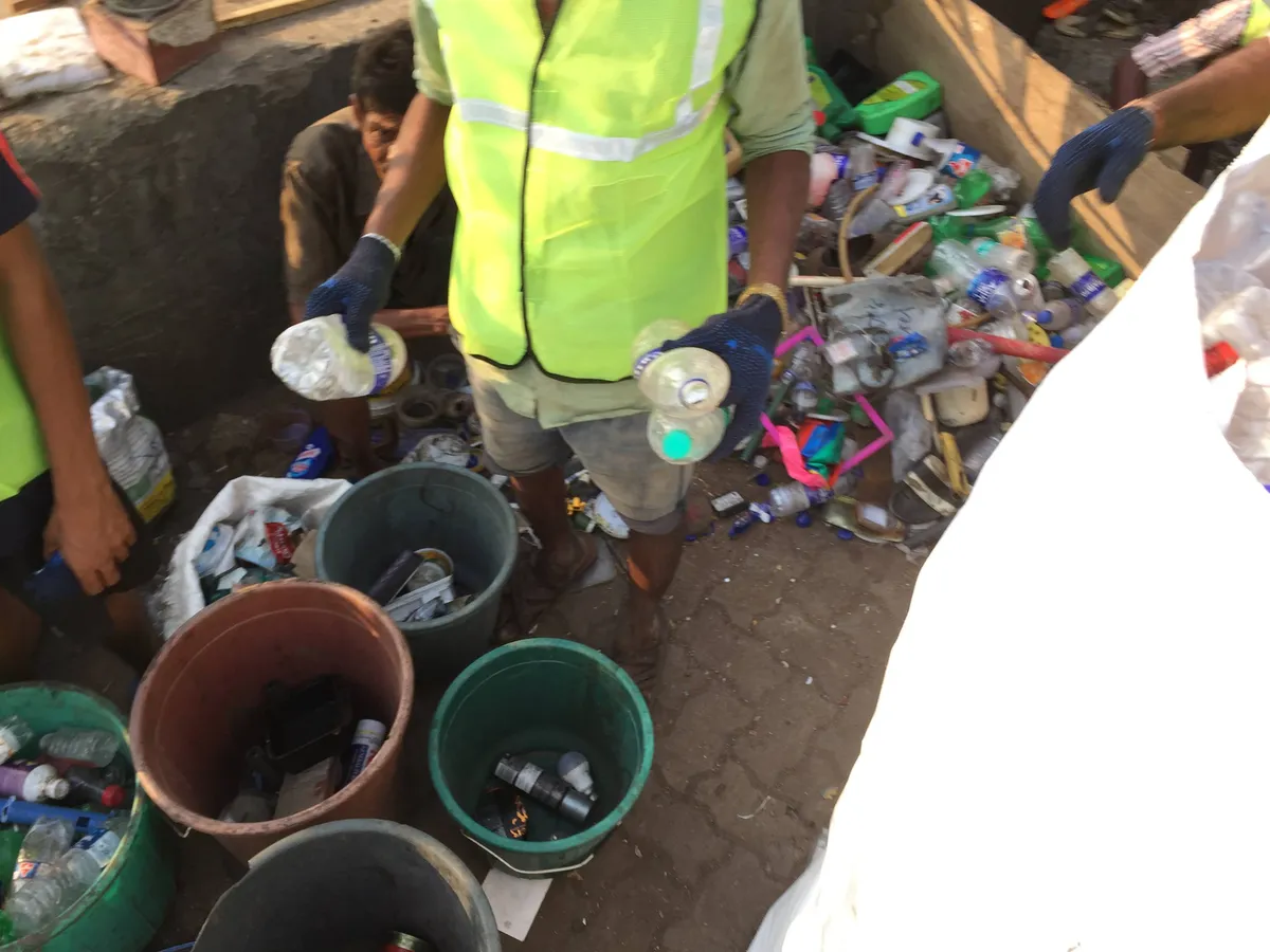 Close-up of recovered plastic waste being sorted into buckets by a waste collector, Earth5R CSR programme in Mumbai
