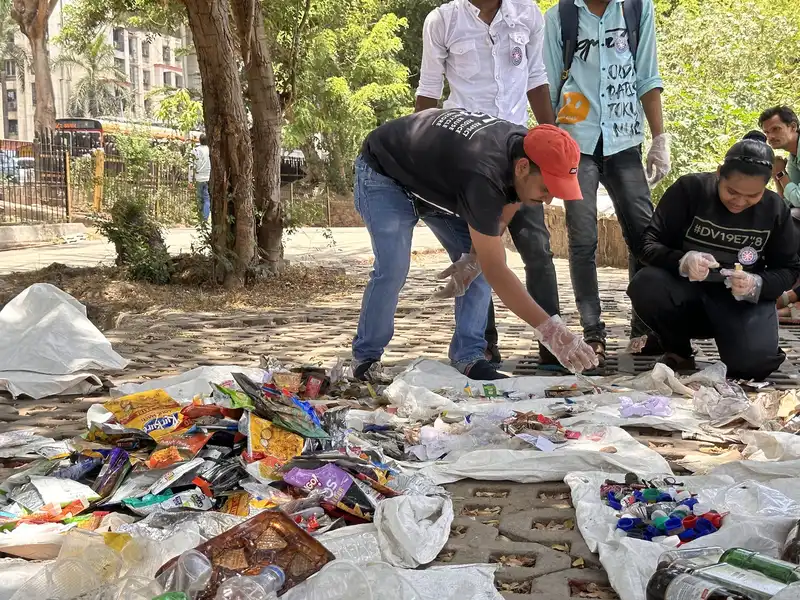 Volunteers sorting multilayer plastic wrappers during the Powai Lake cleanup waste segregation, Earth5R CSR programme