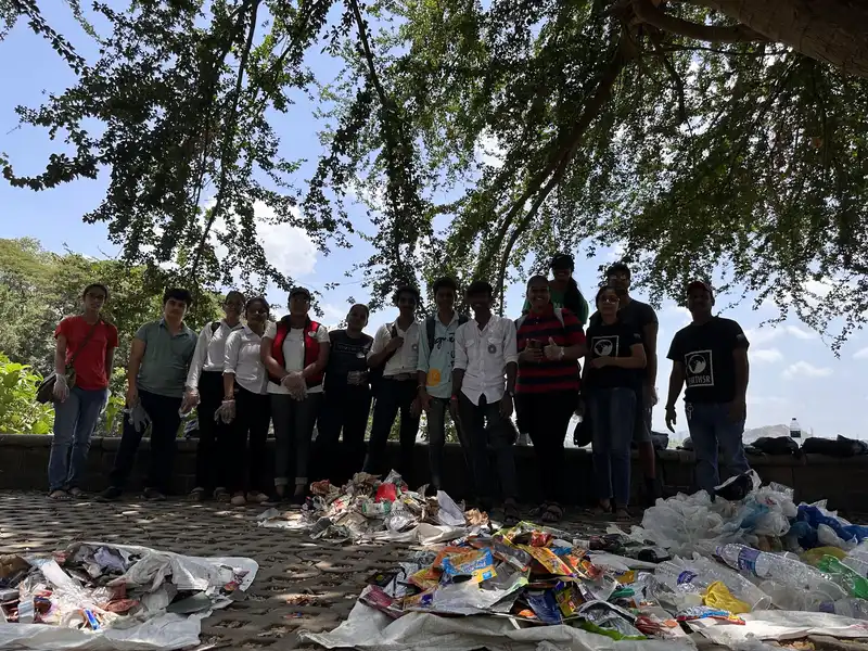 Environmental science internship field work. Volunteers standing behind sorted waste from the Powai Lake cleanup laid out for a waste audit, Earth5R CSR programme