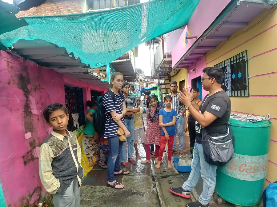 Earth5R trainer explaining rooftop plantation to women and children in an informal settlement in Mumbai