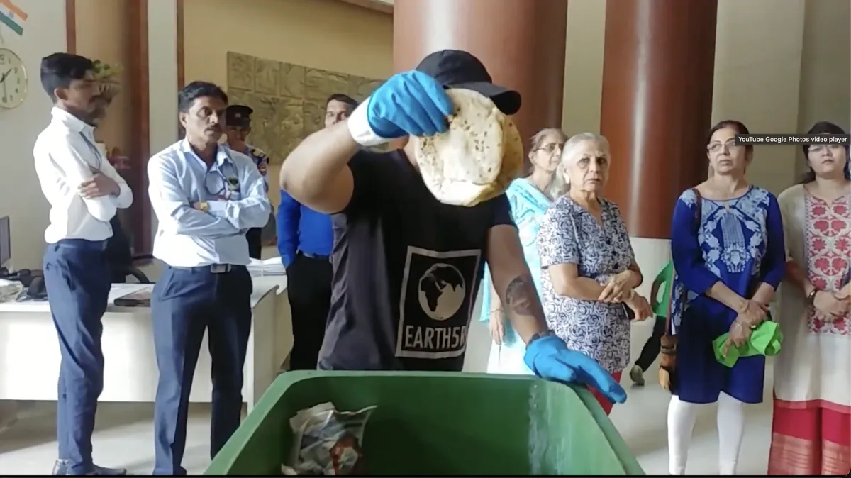 Saurabh Gupta holding up a roti thrown in the garbage to show residents the food waste problem, Earth5R CSR programme