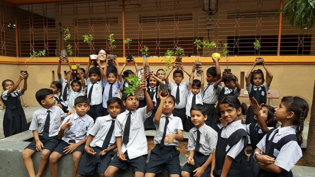 School children raising saplings grown in upcycled plastic planters with Earth5R