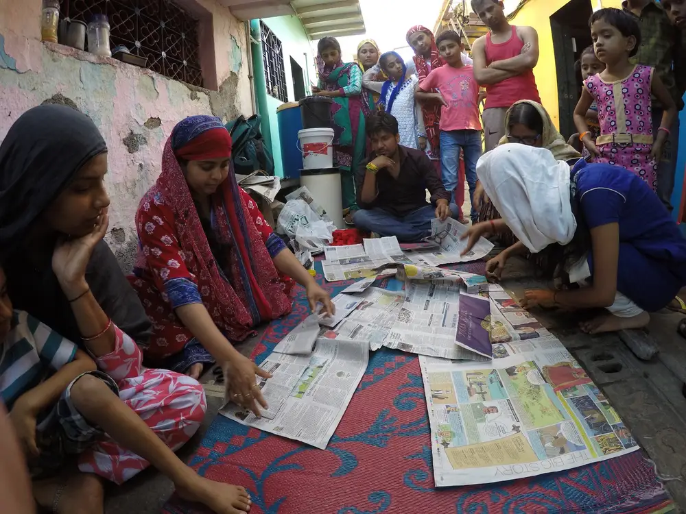 Women folding waste newspaper into paper bags during Earth5R livelihood training