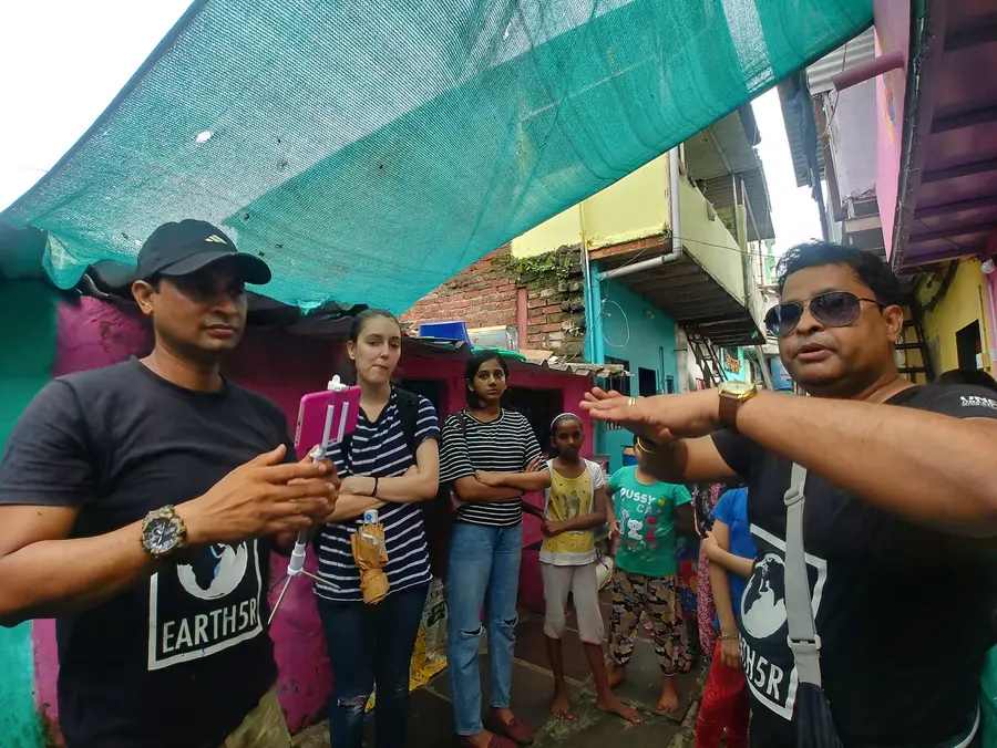 Architecture internship field work. Earth5R team explaining how rooftop plants cool hot tin roofs to settlement residents in Mumbai