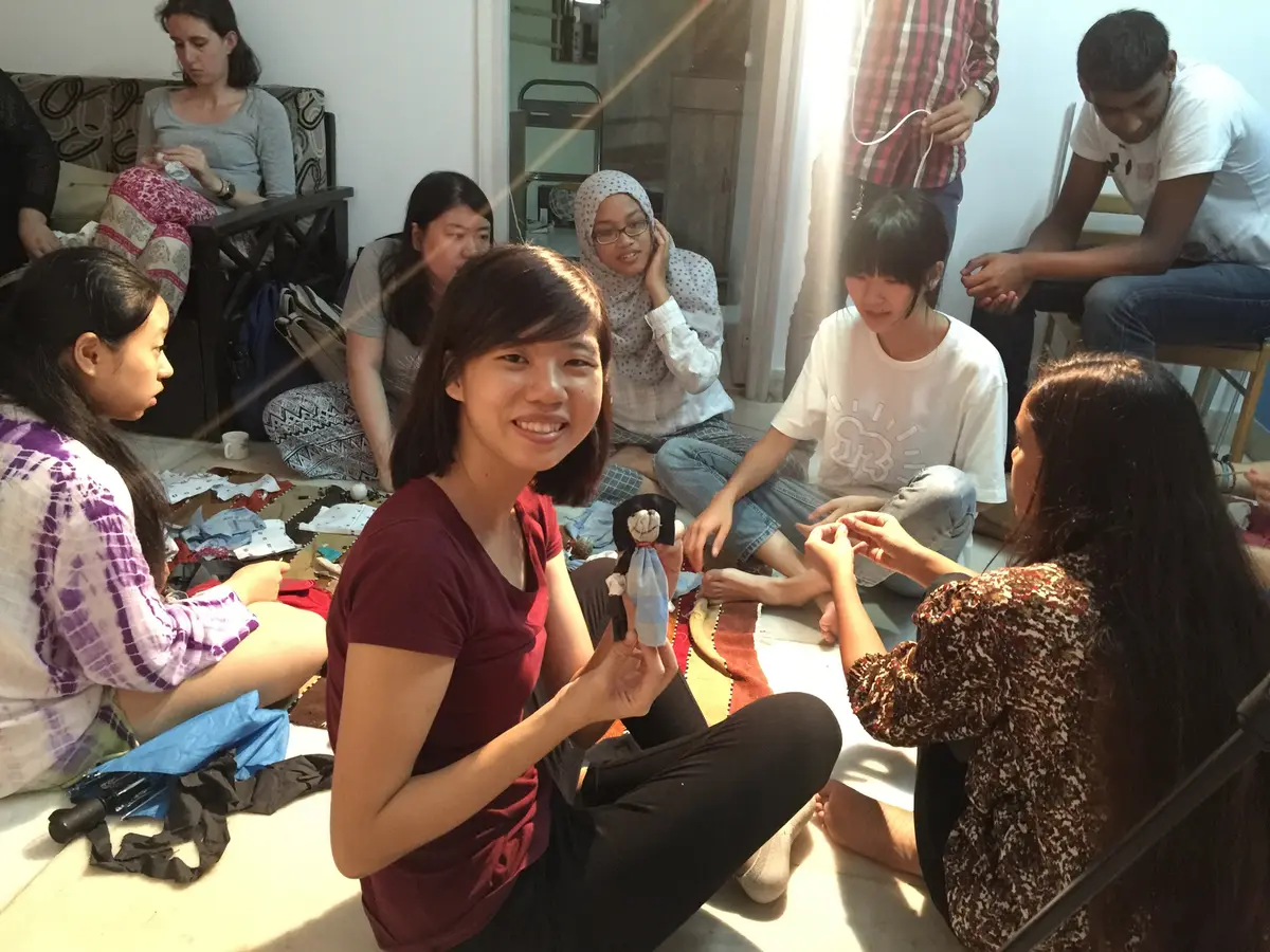 International volunteers making small dolls from fabric scraps, Earth5R CSR programme in Mumbai