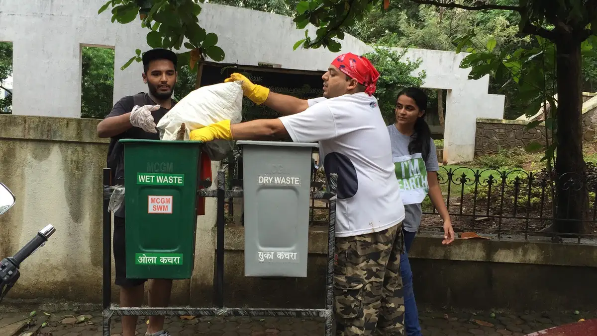 Earth5R volunteers putting collected waste into separate wet and dry waste bins in Mumbai
