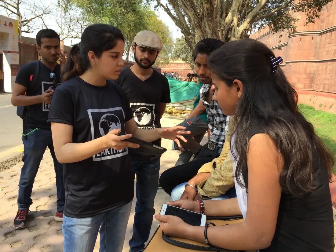 Earth5R volunteers training visitors with a tablet presentation near the Red Fort, Delhi