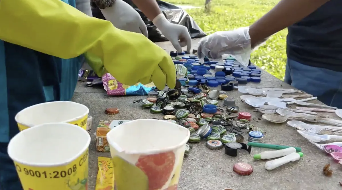 Volunteers sorting bottle caps and wrappers for an Earth5R waste audit that feeds its field data