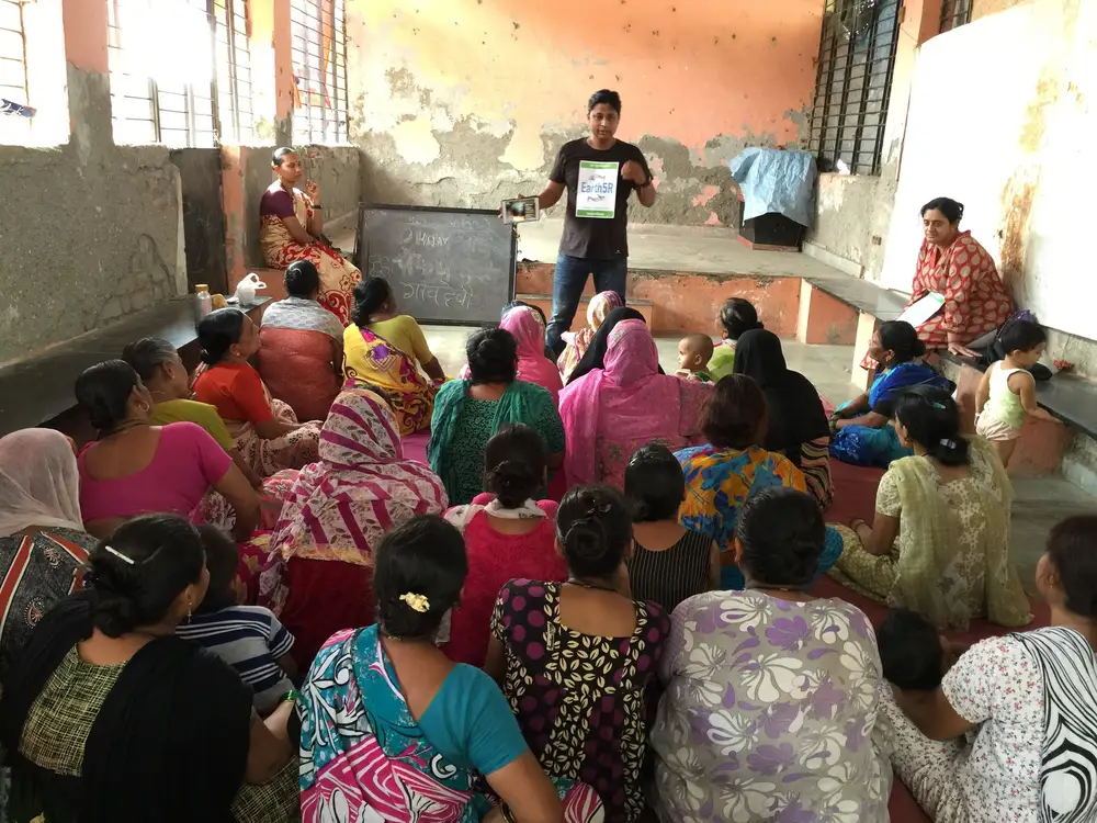 Earth5R facilitator speaking to women seated in a community hall during a waste management workshop in Mumbai