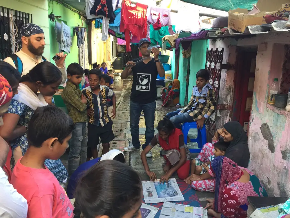 Earth5R volunteers training slum women and children to make paper bags from waste newspaper