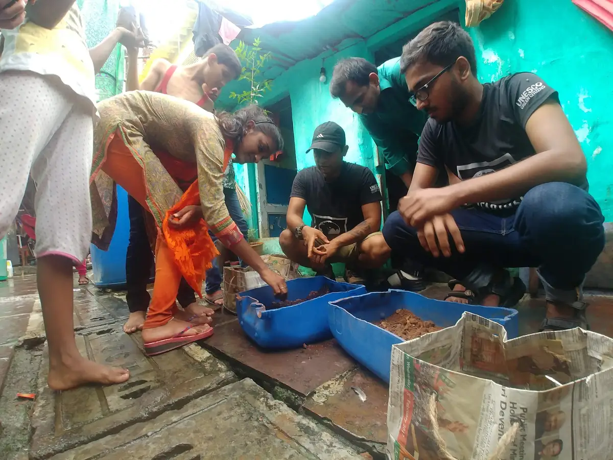 Agriculture internship field work. Women learning to plant saplings in upcycled plastic containers filled with compost and soil, Earth5R CSR programme in Mumbai
