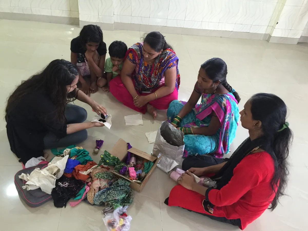 Women and volunteers sorting fabric scraps on the floor for an upcycling activity, Earth5R CSR programme in Mumbai