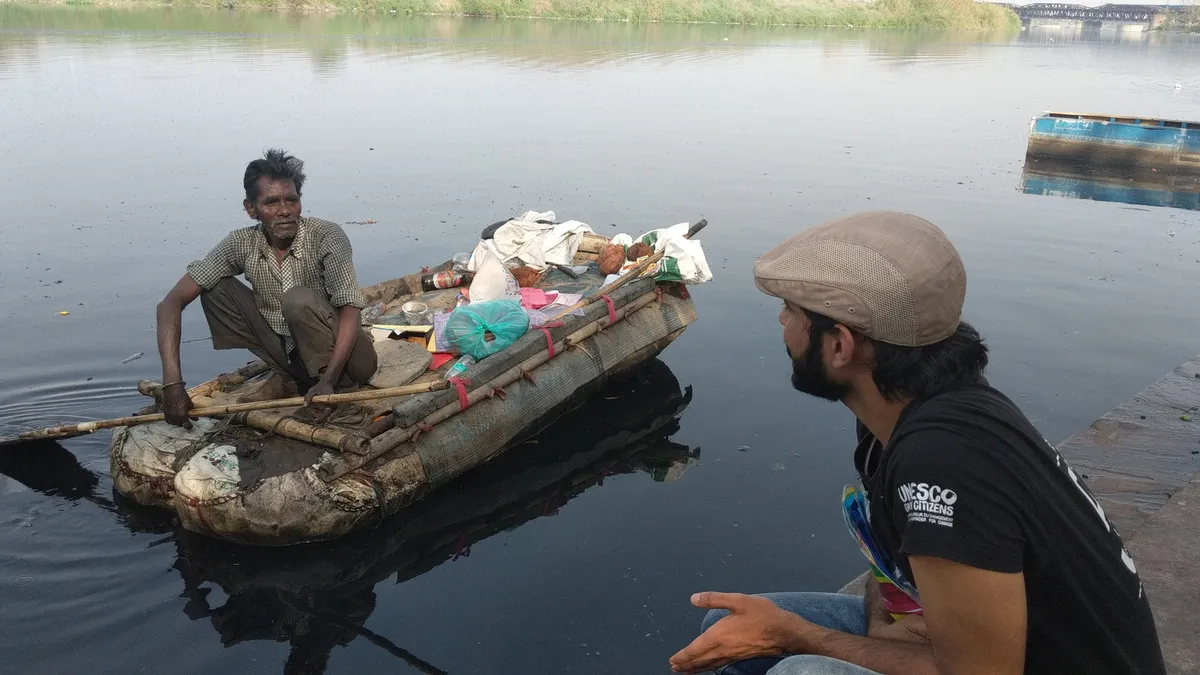 Earth5R volunteer with a local ragpicker who collects waste from the Yamuna River on his raft in Delhi