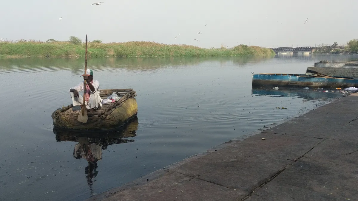 Local ragpicker collecting floating waste on the Yamuna River, an Earth5R social partnership in Delhi
